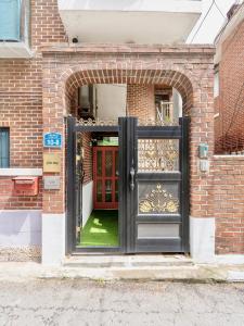 an entrance to a brick building with a black door at Juin - Foreigner only in Seoul