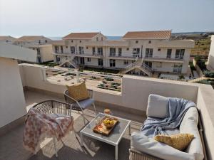 Un balcón con sillas y una bandeja de fruta en una mesa. en Marzamemi Luxury Residence - Affittimoderni, en Marzamemi