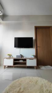 a living room with a flat screen tv on a wall at San Shang Ye - 2BR Baloi Apartment in Nagoya