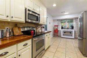 a kitchen with white cabinets and a stainless steel refrigerator at Gorgeous Alabama Home 4 Miles to Stadium Sleeps 8 in Tuscaloosa