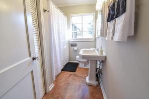 a small bathroom with a sink and a window at Sweet Home Alabama Sleeps 8 in Tuscaloosa +33 photos