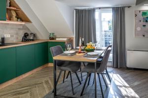 une cuisine avec des placards verts et une table en bois avec des chaises dans l'établissement 8th Hill, à Plovdiv