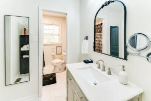 タスカルーサにあるLA Maison De LA Nouvelle-Orléans GAME DAY house Covered Patioの洗面台と鏡のある白いバスルーム +27枚の写真