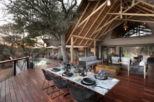 an outdoor dining area with a table and chairs on a deck at Serondella Game Lodge in Thornybush Game Reserve