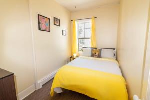 - une chambre avec un lit jaune et une fenêtre dans l'établissement Cozy 3-Bdrm for the family, in Uptown Saint John Parking Coffee, à Saint-Jean