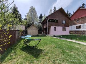 ein Hof mit einer Bank im Gras neben einer Scheune in der Unterkunft Casa Soveja Rucareni in Soveja