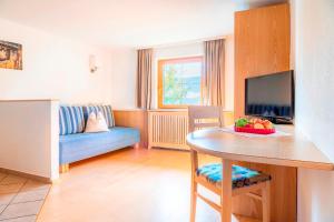 ein Wohnzimmer mit einem Tisch und einem blauen Sofa in der Unterkunft Prechtlhof in Flachau in Flachau