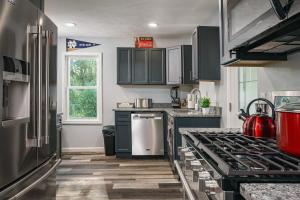 a kitchen with black cabinets and a stove top oven at The Lucky Charm Home of the Fighting Irish! BBQ Outdoor Games Coffee in South Bend
