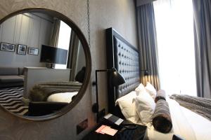 a hotel room with a mirror and a bed at Hotel Gotham in Manchester
