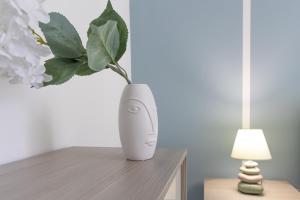 un vaso bianco con una pianta sul tavolo di Verde Salmastro a Livorno