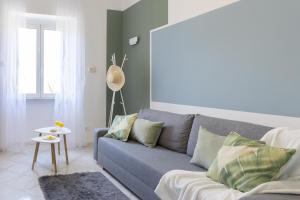 un soggiorno con un divano grigio e un tavolo di Verde Salmastro a Livorno