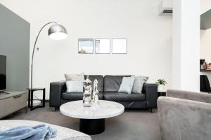 sala de estar con sofá y mesa en Premium 2BD Loft DT Heated Parking Rooftop Patio BBQ Gym Coffee, en Winnipeg