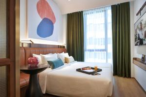 a hotel room with a bed and a window at Citadines Connect City Centre Singapore in Singapore