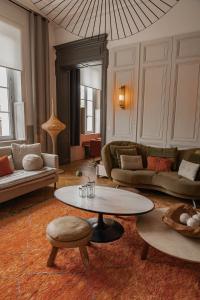 een woonkamer met banken en een tafel bij La Maison Mulatô, demeure privée d'hôtes, piscine & spa Libourne, Saint-Emilion in Libourne