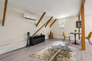 sala de estar con mesa, sillas y alfombra en The Lily Pad Modern Cottage In The City en Mobile