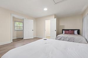 ein weißes Schlafzimmer mit einem Bett und einem Fenster in der Unterkunft The Lily Pad Modern Cottage In The City in Mobile