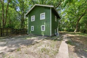 ein grünes Haus inmitten eines Gartens in der Unterkunft The Lily Pad Modern Cottage In The City in Mobile