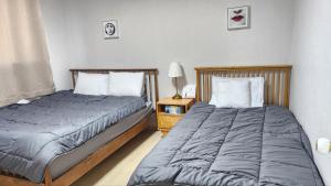 two beds sitting next to each other in a bedroom at 2room with 4beds near kintex daehwa station in Goyang