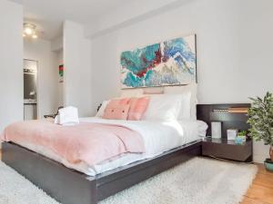 een slaapkamer met een groot bed met roze kussens bij Fun and Colourful Condo w Foosball Parking Coffee in Calgary