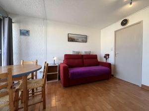een woonkamer met een rode bank en een tafel bij Appartement Gruissan, 1 pièce, 3 personnes - FR-1-229-882 in Gruissan