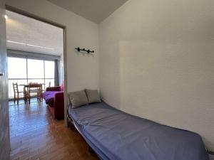 een kamer met een bed in een kamer met een tafel bij Appartement Gruissan, 1 pièce, 3 personnes - FR-1-229-882 in Gruissan