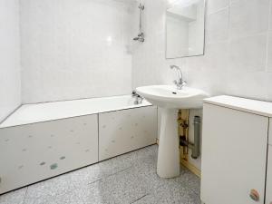La salle de bains blanche est pourvue d'un lavabo et d'une baignoire. dans l'établissement Spacieux appartement sur les quais de la Chaume - 6 pers, à Les Sables-dʼOlonne