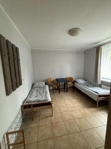 een kamer met 2 bedden en een tafel en stoelen bij Relaks Noclegi in Częstochowa
