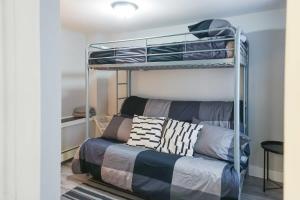 a bedroom with a bunk bed and a couch at NEW Renovated Cozy 2 Br in Uptown Saint John Location Coffee in Saint John