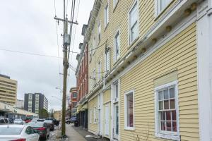 a yellow building on the side of a street at NEW Renovated Cozy 2 Br in Uptown Saint John Location Coffee in Saint John