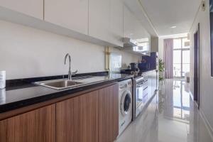 a kitchen with a sink and a washing machine at Frank Porter - DAMAC Hills Jasmine in Dubai