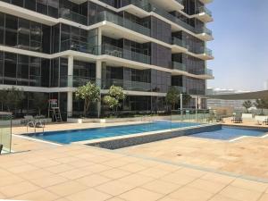 a large building with a swimming pool in front of it at Frank Porter - DAMAC Hills Jasmine in Dubai