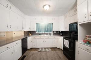 a kitchen with white cabinets and a sink and a window at The Cozy Retreat l 4-Bedrooms WiFi Long Stays in Birmingham