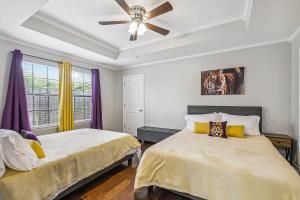 Un dormitorio con dos camas y un ventilador de techo. en Cozy Retreat in the Heart of Baton Rouge, en Baton Rouge