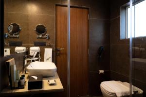 y baño con aseo, lavabo y ducha. en The Fern Wisteria Resort, Dhari, en Dhāri