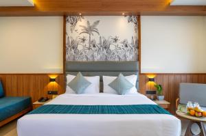1 dormitorio con 1 cama grande y 1 sofá azul en The Fern Wisteria Resort, Dhari, en Dhāri
