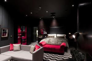 a bedroom with a red bed and a couch at Hotel Gotham in Manchester