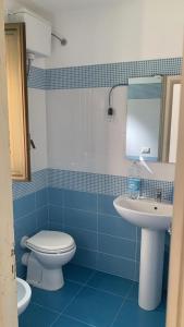 uma casa de banho azul e branca com um WC e um lavatório em Villa indipendente sul mare - Maiolica home&welfare em Alcamo Marina