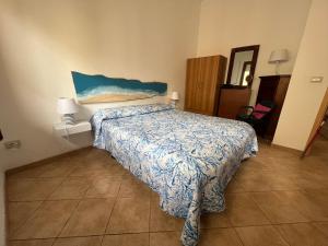 um quarto com uma cama com um edredão azul em Villa indipendente sul mare - Maiolica home&welfare em Alcamo Marina