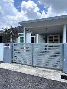 a white fence in front of a house at D' Permata Homestay Kulim in Kulim