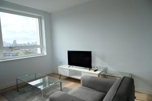 ein Wohnzimmer mit einem Sofa und einem TV in der Unterkunft Luxury 2B2B in central London in London