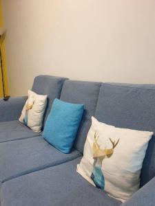 a blue couch with three pillows and a deer on it at D' Permata Homestay Kulim in Kulim