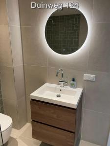 un baño con lavabo y espejo en Appartementen Zuiderstrand H, en Westkapelle