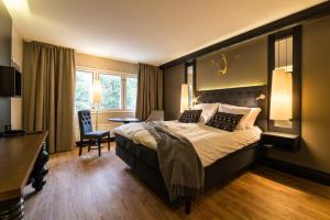 
a hotel room with a bed, chair, and nightstand at Lapland Hotels Tampere in Tampere
