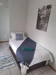 a bedroom with a bed with a blue blanket at Honey Bee Guesthouse in Rustenburg