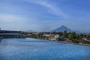 a large swimming pool with a city in the background at Grand Edge Hotel Semarang - CHSE Certified in Semarang