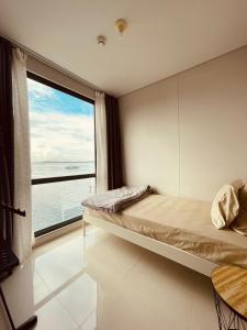 a bedroom with a bed and a large window at Vanilla One Residence Apartment Batam in Batam Center
