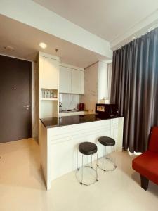 a kitchen with two stools and a counter in a room at Vanilla One Residence Apartment Batam in Batam Center