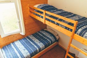 two bunk beds in a room with a window at Terres de France - Les Hameaux des Marines in Saint-Denis-dʼOléron