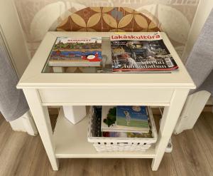 ein weißer Tisch mit Zeitschriften darüber in der Unterkunft Brody Art Boutique Apartment in Budapest