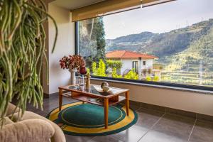 un soggiorno con tavolo e una grande finestra di Fraga Douro House, Douro Valley a Resende